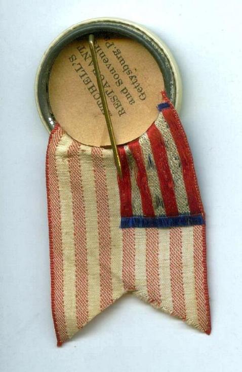 Beautifully Preserved Celluloid Pinback with Original Paper Label & Flag Ribbon From the 1938 Blue & Gray Reunion at the 75th Anniversary of the Battle of Gettysburg, Pennsylvania.