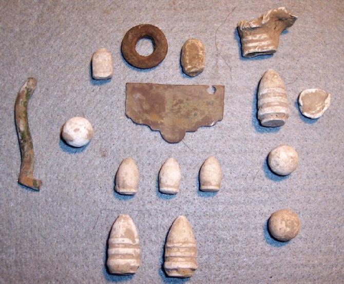 Relics recovered from a Missouri State Guard Camp, mid October. Broken end of a sword belt plate, top of a badge, and several Sharps Carbine Bullets . 