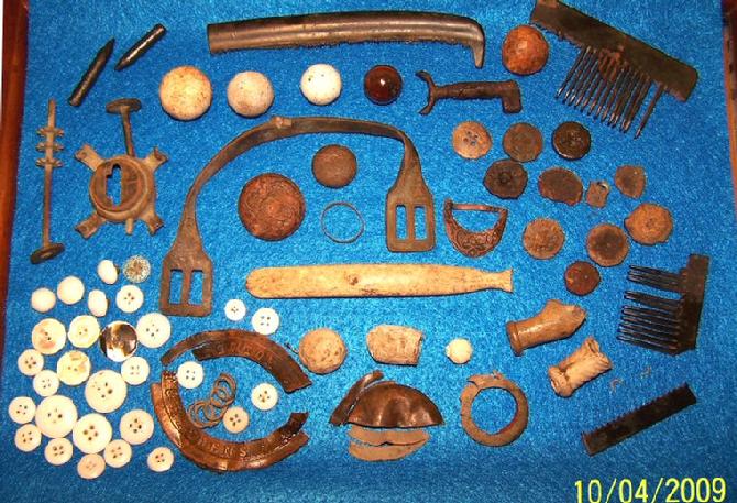 Several hard rubber combs, spur, variety of metal, glass, and bone buttons, pipe stems, and other miscellaneous items 